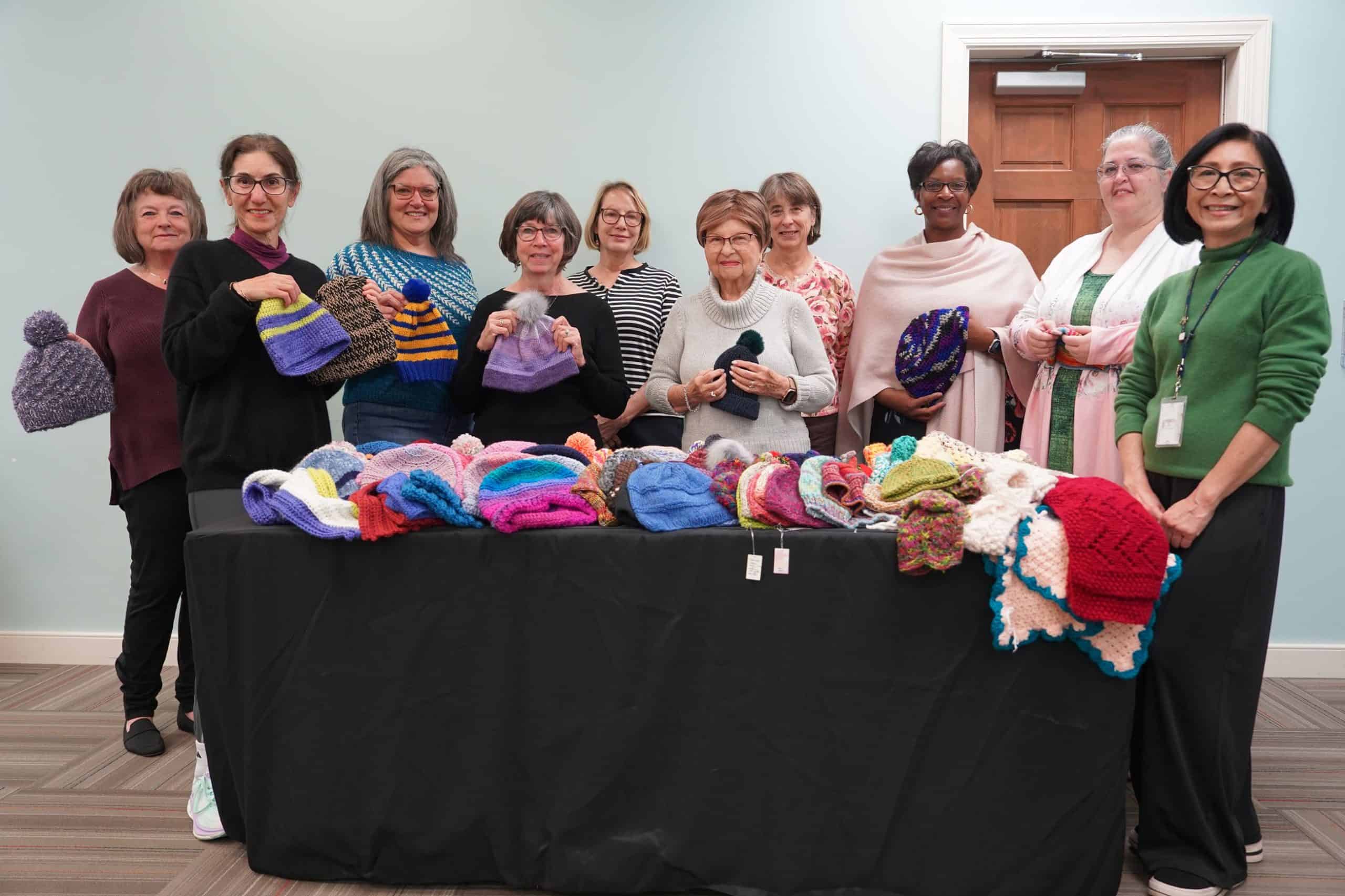 Group photo of Knit Night attendees holding donations